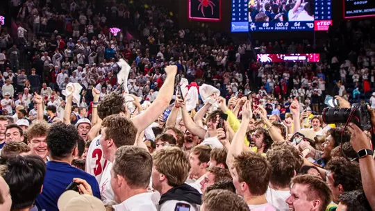 Spiders center Neal Quinn celebrates with fans after they stormed the court following Richmond's win vs Dayton