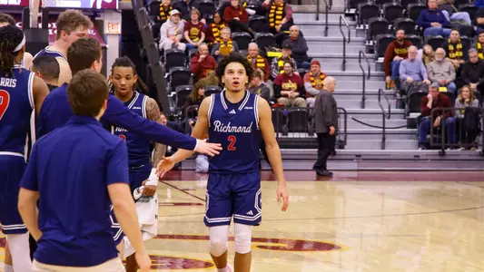 Jordan King slaps hands with teammates while walking back to the Richmond bench after a timeout at Loyola Chicago.