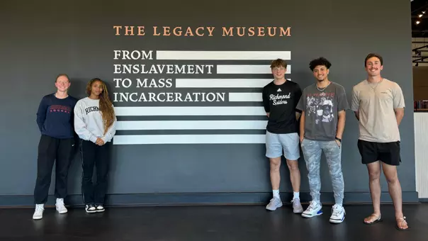 Five student-athletes pose outside a museum in Alabama