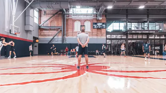 Chris Mooney stands at midcourt and surveys practice in the Queally Athletics Center