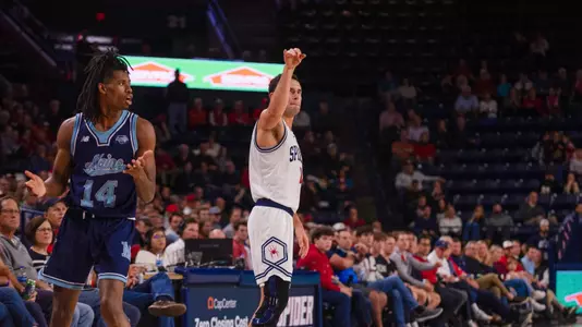 Jason Roche holds his follow through after a three-point basket