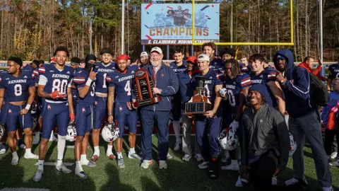 John Hardt poses with the CAA championship trophy following a win vs William & Mary