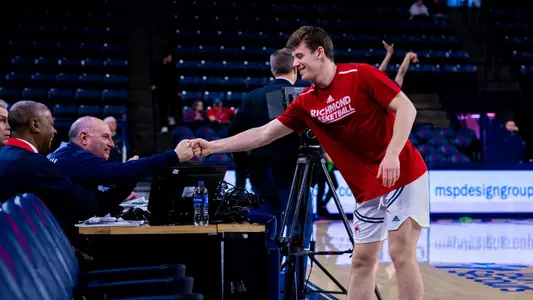 Liam Weaver bumps fist with SpiderTV host Bob Black before a game