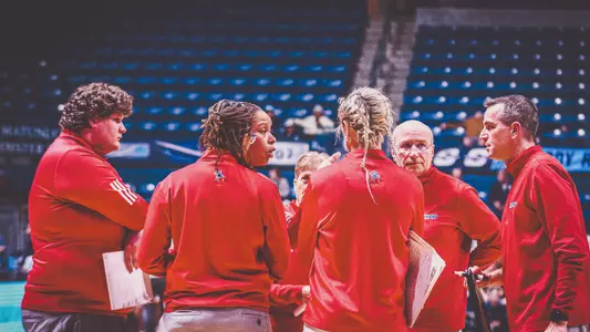 Women's Basketball Coaches huddled during a timeout