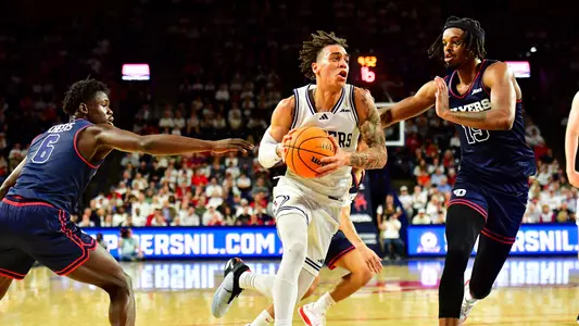 Dji Bailey drives to the lane against Dayton's DaRon Holmes