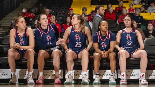 Women's Basketball starting five on the bench pregame