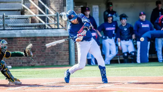 Jason Shockley, wearing a blue jersey top and white pants, swings at the ball.