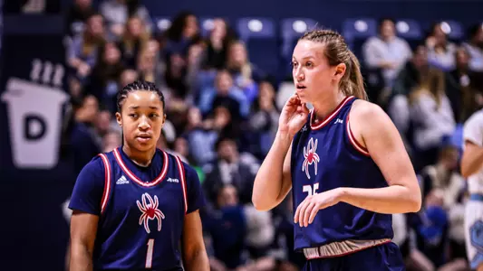 Katie Hill and Grace Townsend looking around during a basketball game