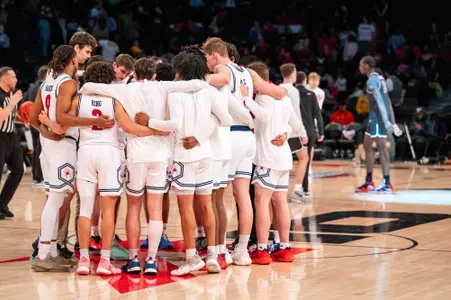 The Spiders huddle near midcourt at the Barclays Center