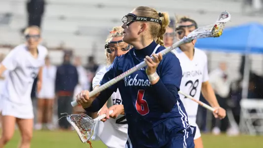 Ali Susskind close up photo looking to pass the ball with UVA defenders around her