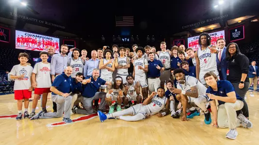 Richmond men's basketball team poses on the court after winning the A-10 regular season title