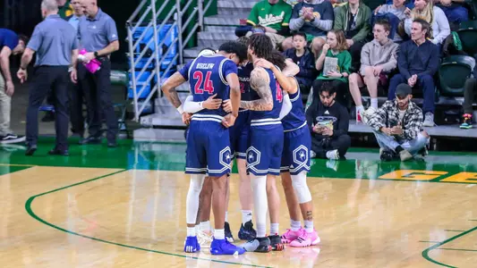 Richmond's starters huddle together on the court prior to tip-off
