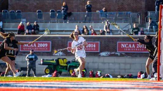 Sarah Roycroft shooting the ball at the free position with a defender on each side of her