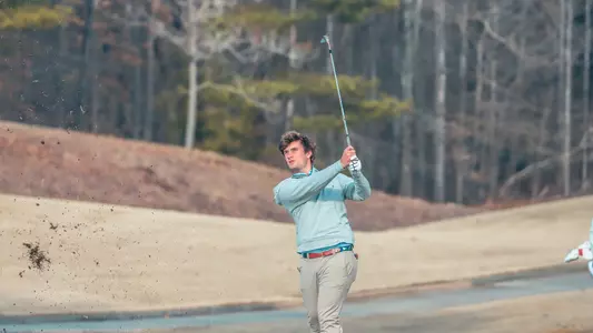 Jack LaPiana focuses on his approach shot as his divot flies in the air