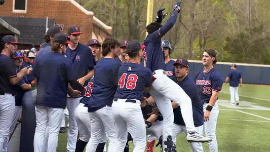 The baseball team catches Aaron Whitley in celebration of a home run