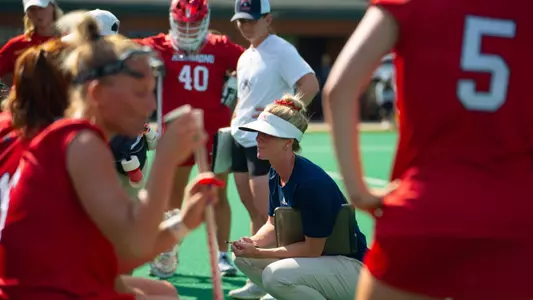 Anne Harrington talking to her team as they sit on the bench between quarters
