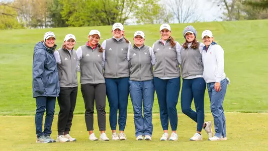 Members of Richmond's women's golf team pose with coach Calle Barlow on the first tee box