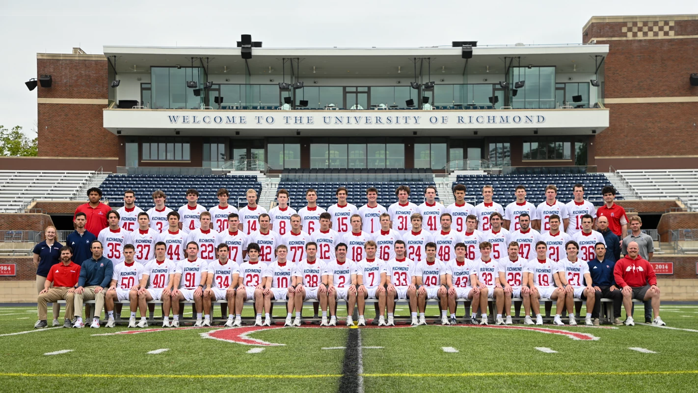 2024 men's lacrosse team photo featuring all 49 players and team staff on the field at Robins Stadium