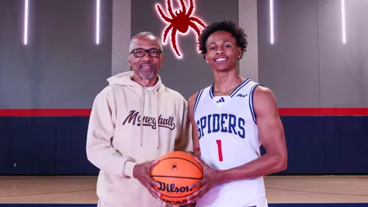 B. Artis White and his father pose on the Queally Athletics Center court