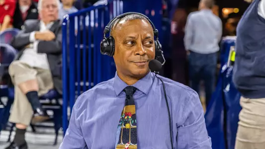 Greg Beckwith looks to his left while wearing a headset at the radio table in the Robins Center