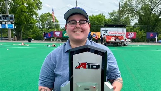 Malloreigh Yingling poses on the field with the 2023 A-10 Women's Lacrosse trophy