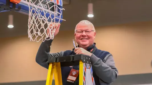 John Hardt holds up a piece of the net following the 2024 A-10 Women's Basketball Championship