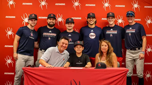 Team Impact athlete Parker Plank with his parents Marty and Janet are surrounded by Spider baseball team members