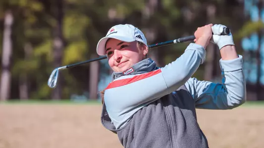 Christine Mandile watches her tee shot approach the green