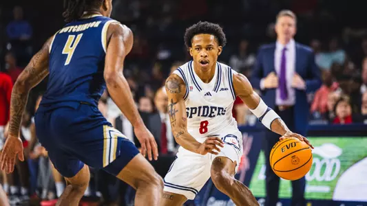 B. Artis White dribbles in front of the UR bench during a game