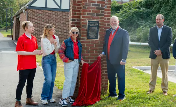 John Hardt helps unveil a plaque honoring former Spider women's tennis coach Mark Wesselink