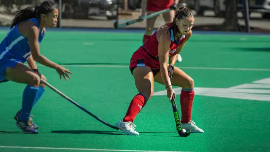 Spider field hockey's Lillian Buckwalter protects the ball from her opponent