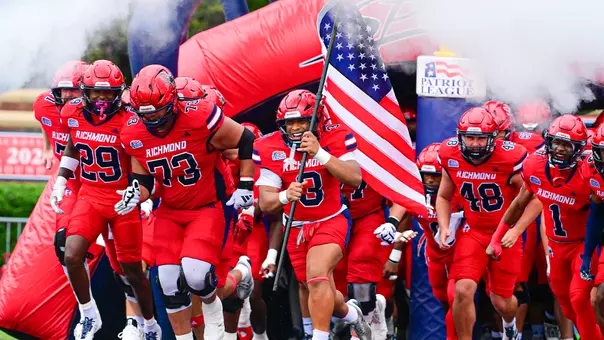 Flag-bearer Aziz Foster-Powell leads Richmond out of the tunnel ahead of its game against Holy Cross