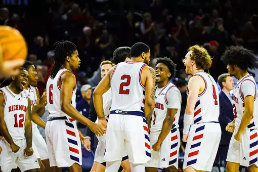 Members of the men's basketball team celebrate at a timeout