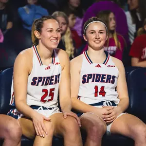 Katie Hill and Ally Sweeney smiling on the bench
