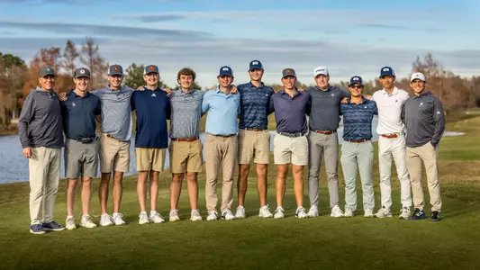 The 2025 men's golf team poses on a green during a round in Florida