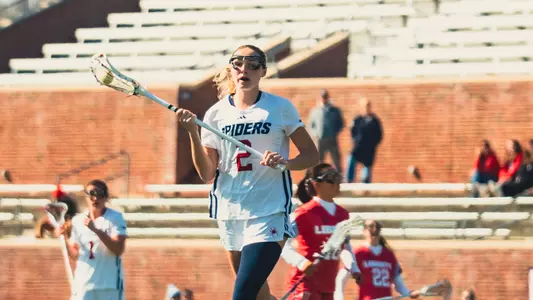 Grace Muldoon carries the ball upfield during Richmond's game against Liberty on Feb. 22, 2025