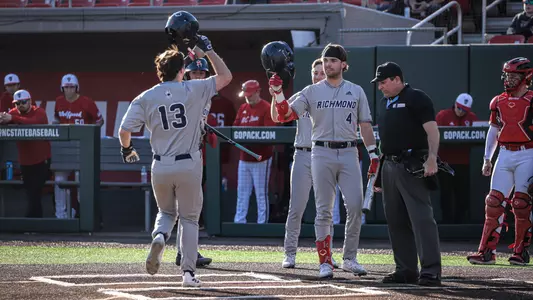 Jordan Jaffe (13) raises his helmet to celebrate a home run with team mate Jack Arcamone against NC State