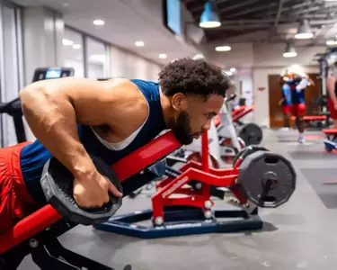 A man lift weights while lying on an exercise bench
