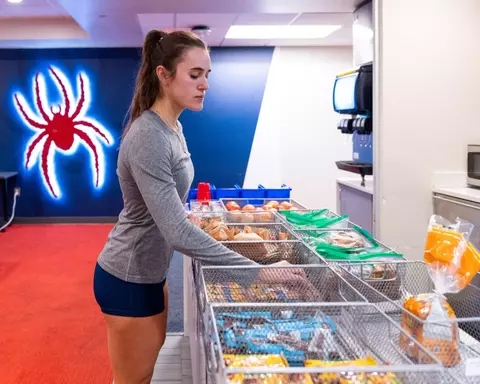 A woman inspects food options at a training station
