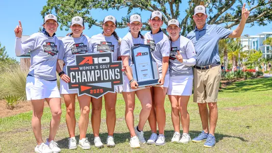 Members of the women's golf team pose with the 2025 A-10 Championship trophy