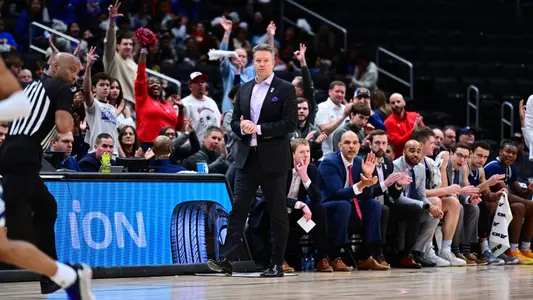Chris Mooney watches play while standing by the bench