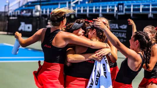 Women's tennis celebrating after defeating Duquesne