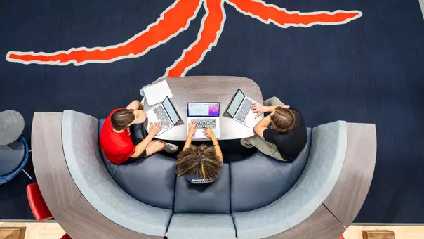 An overhead view of three students studying in Millhiser Academics Center