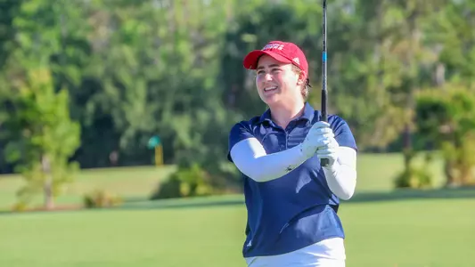 Caroline Thompson reacts after hitting a shot from the fairway