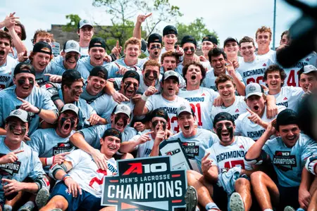 Members of the men's lacrosse team celebrate after winning the A-10 title