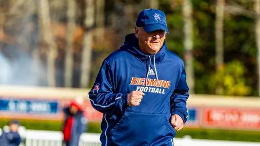 Spiders head coach Russ Huesman runs out of the tunnel ahead of Richond's 2024 FCS Playoffs game against Lehigh
