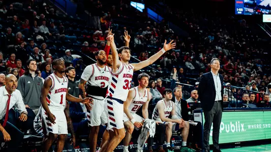 Apostolos Roumoglou shoots a three in front of the Spiders bench
