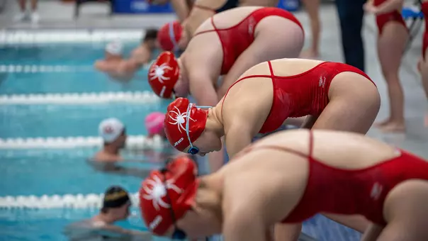 Richmond swimmers prepare to dive into the pool during the Richmond Duals