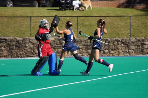 Spider Hockey defenders celebrate with goalkeeper Mairead Carey