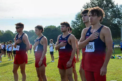 Members of the men's cross country team stand during the national anthem